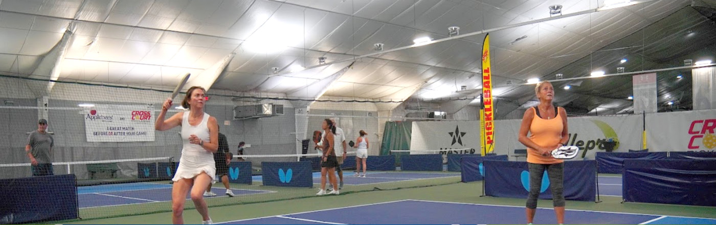 Photo of two women playing on an indoor Picklebal court