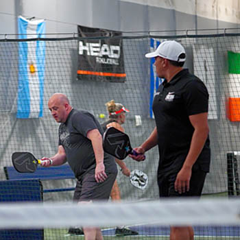 Photo of two adult men playing pickleball